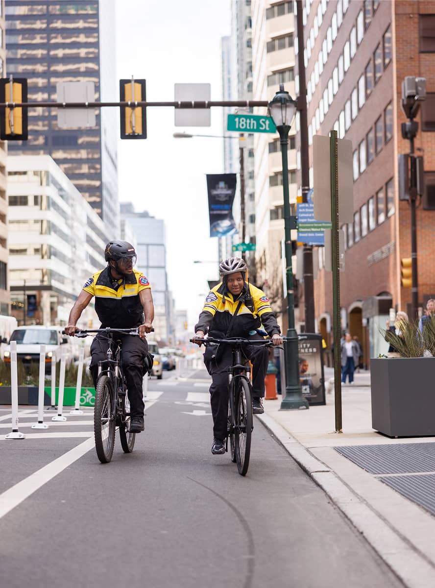 CCD public safety bike patrol officers, wearing yellow jackets, bike helmets and carrying a 2-way radio, riding on their bikes.