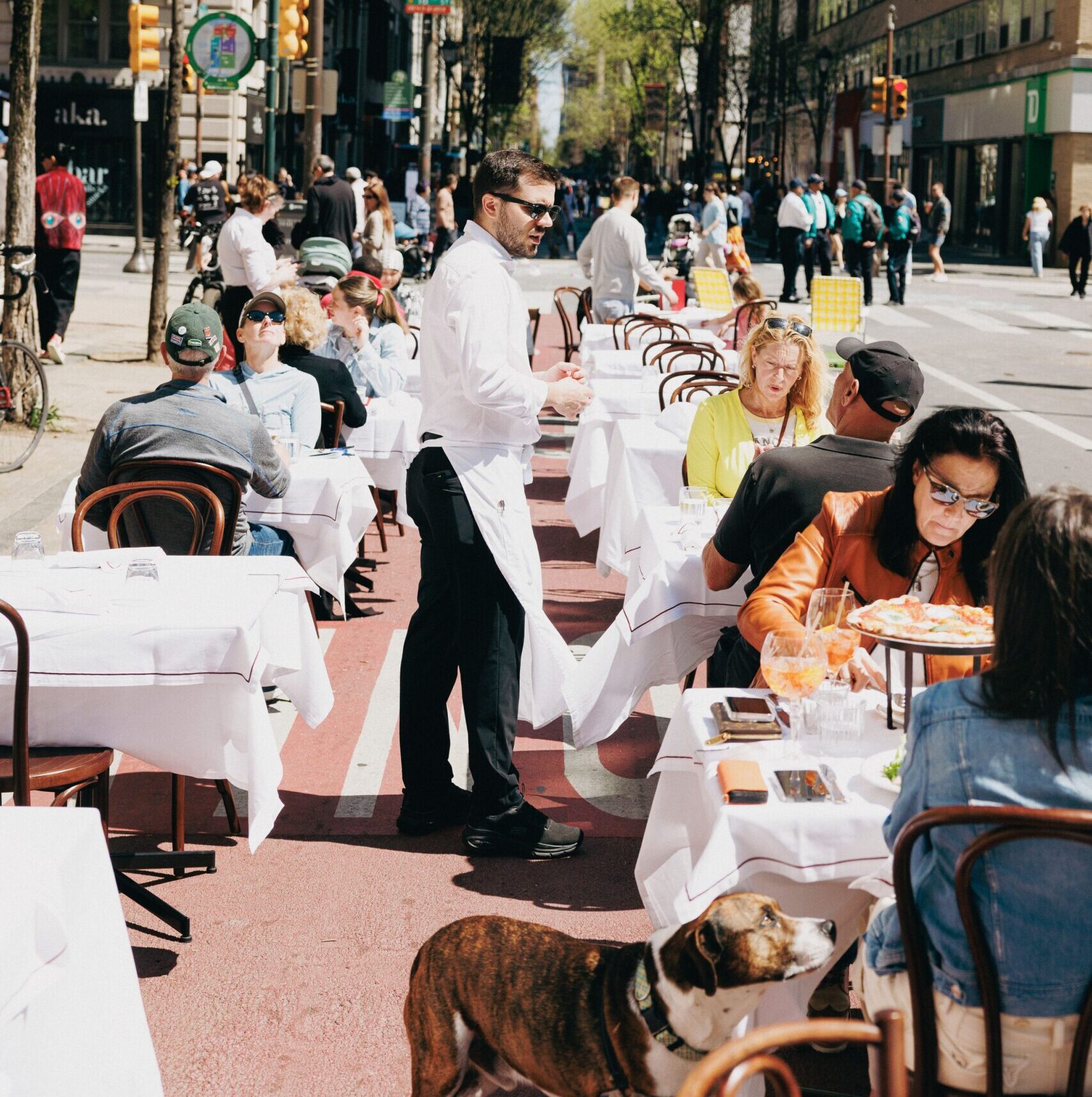 People dining at a restaurant that has expanded their seating into the streets in center city philadelphia.